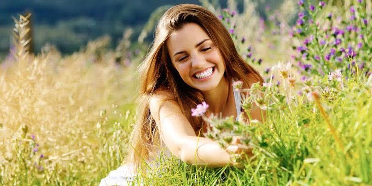 Woman of a girl picking flowers in the field